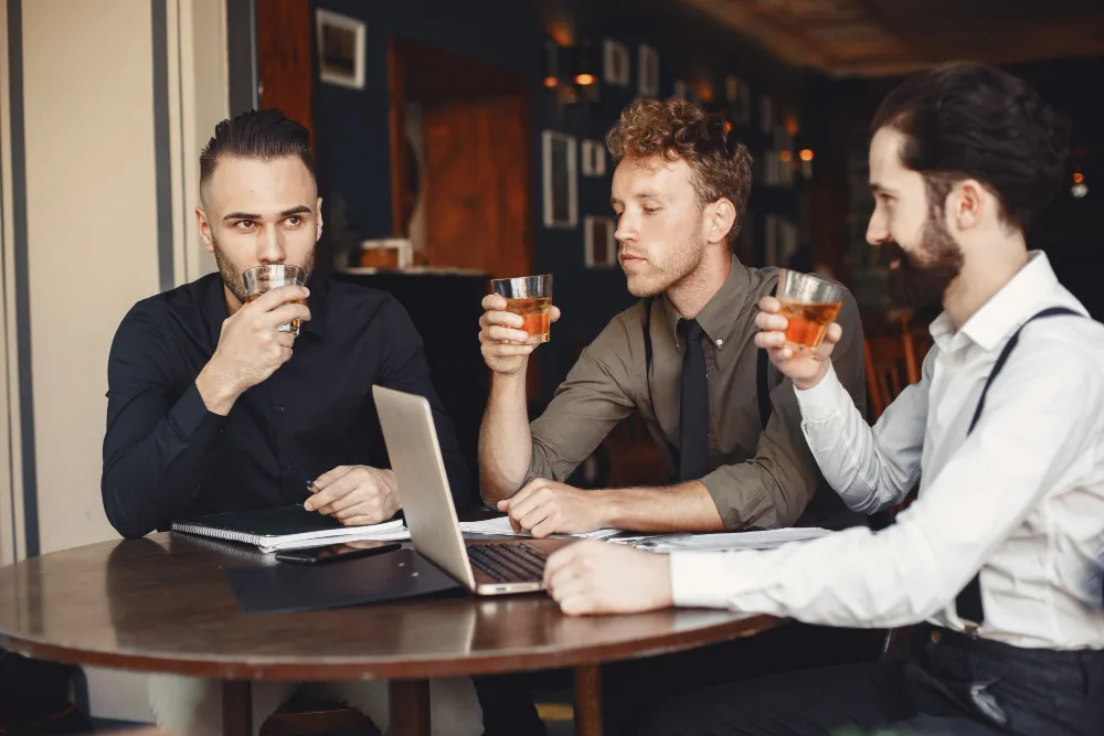 Two business professionals in discussion in a pub-style setting, representing sales and marketing alignment