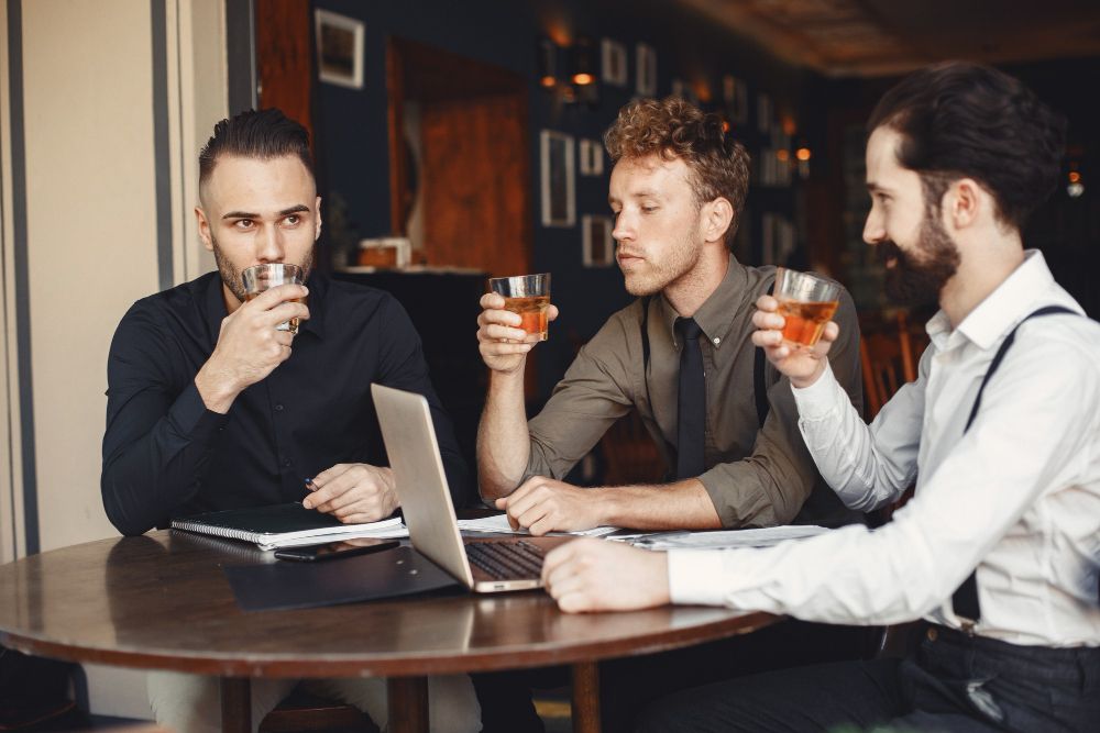 Two business professionals in discussion in a pub-style setting, representing sales and marketing alignment